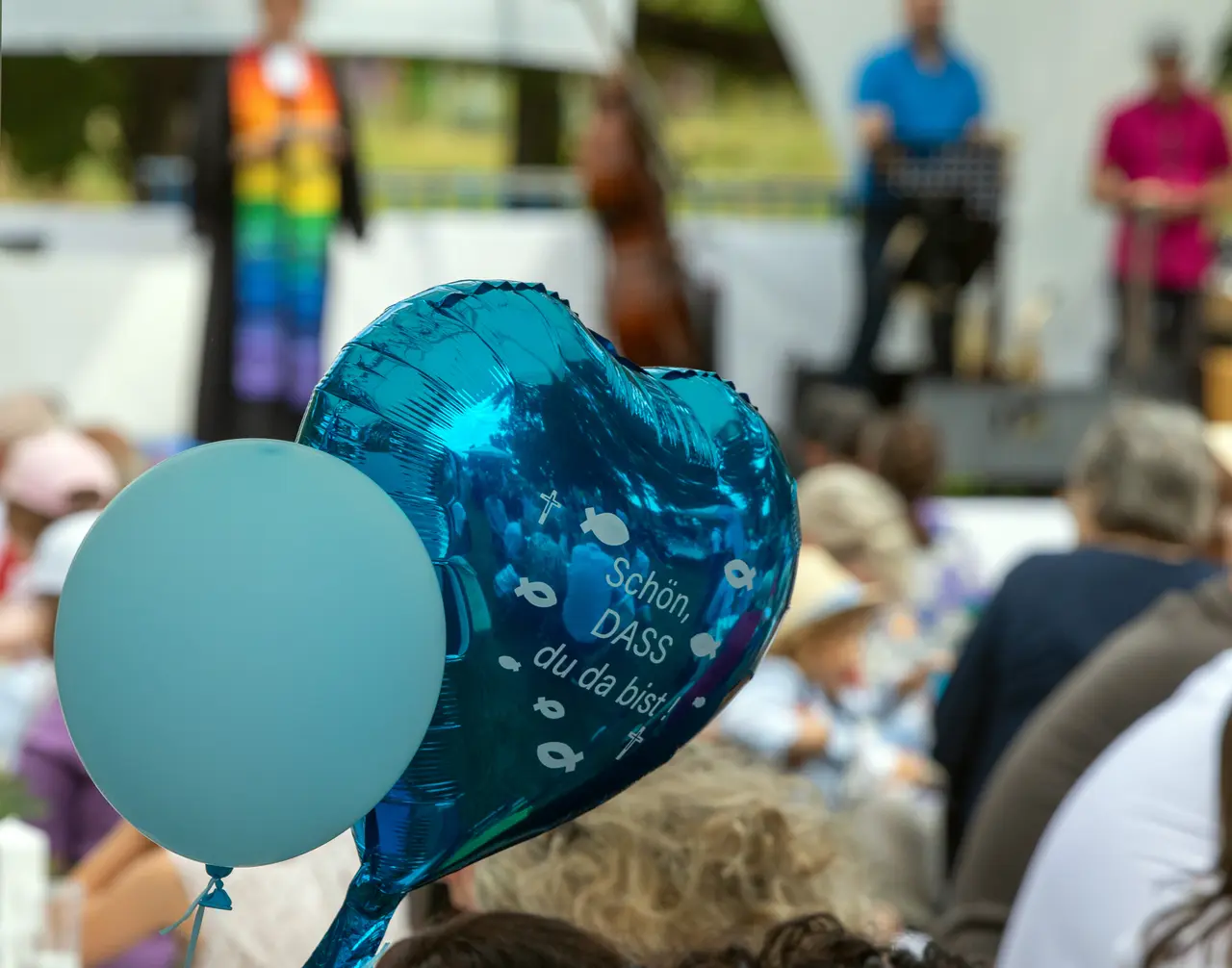 Zwei Luftballons beim &quot;Main Tauffest 2022&quot;. Einer ist herzförmig und trägt die Aufschrift &quot;Schön, dass du da bist&quot;.